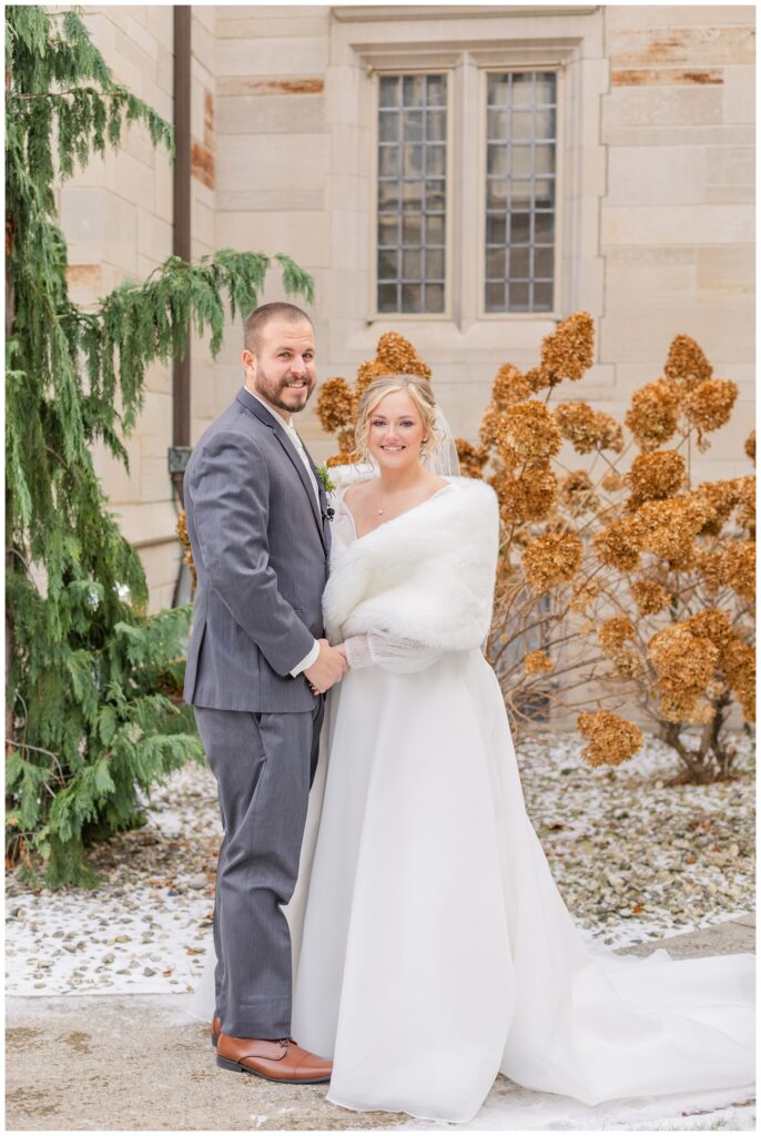 bride and groom portraits outside in the snow at the church in Fremont, Ohio 