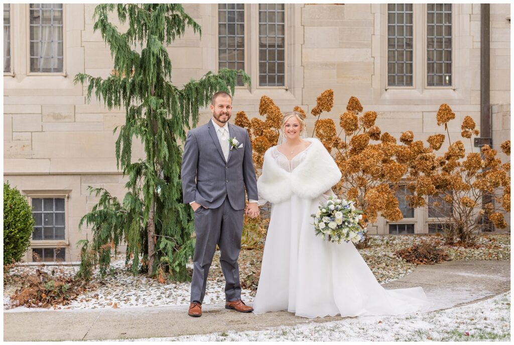 wedding couple holding hands on the sidewalk outside the church in Fremont, Ohio