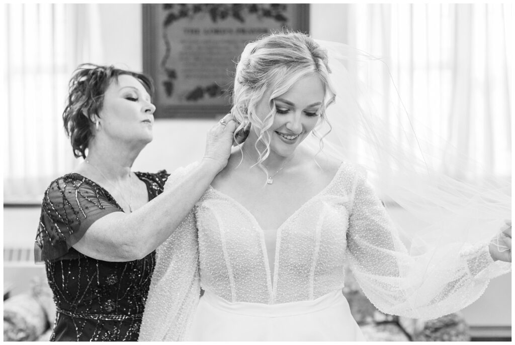 bride's mom adjusting the bride's veil before the wedding church ceremony 