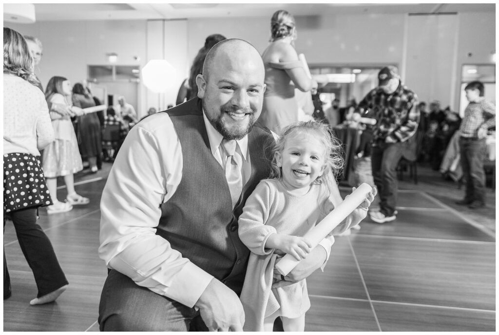 groomsmen and his daughter posing for a photo at winter reception in Fremont, Ohio