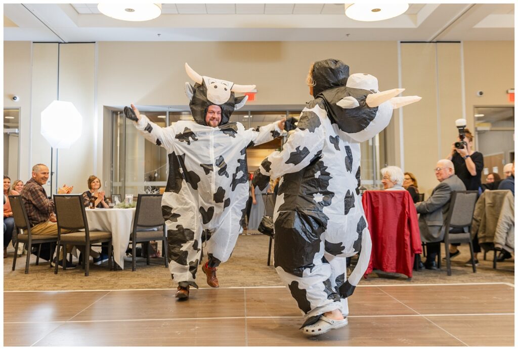 two members of the wedding party dressed like cows walking into the reception