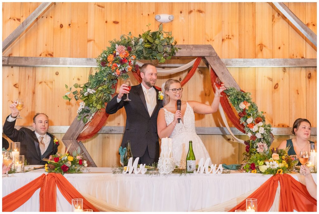 bride and groom saying a few words from their table at wedding reception