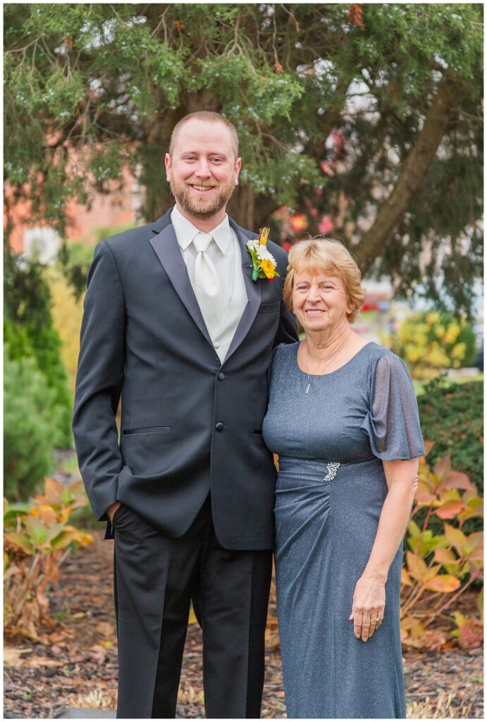 groom posing with his mom outside before the wedding at a church in Ohio