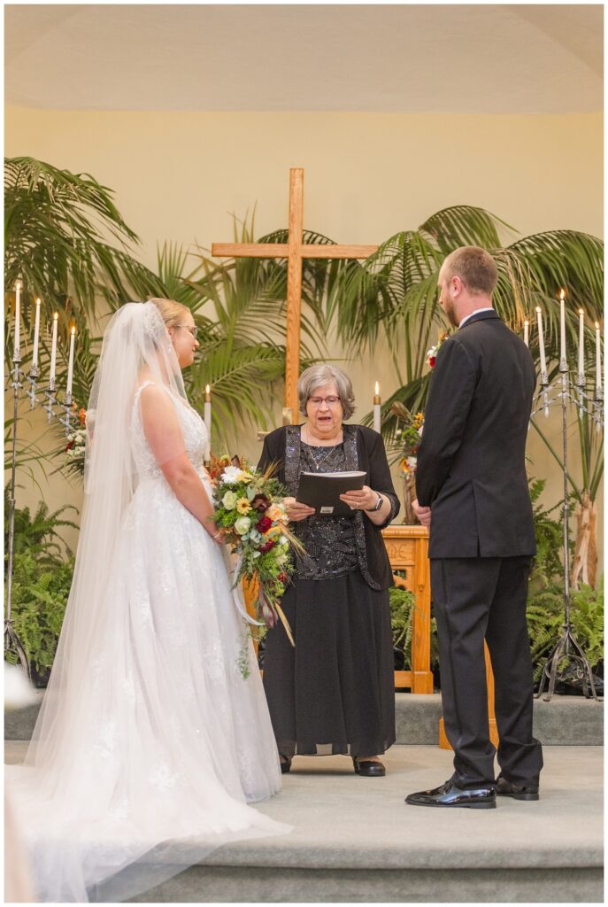 wedding couple standing at the altar listening to the pastor 