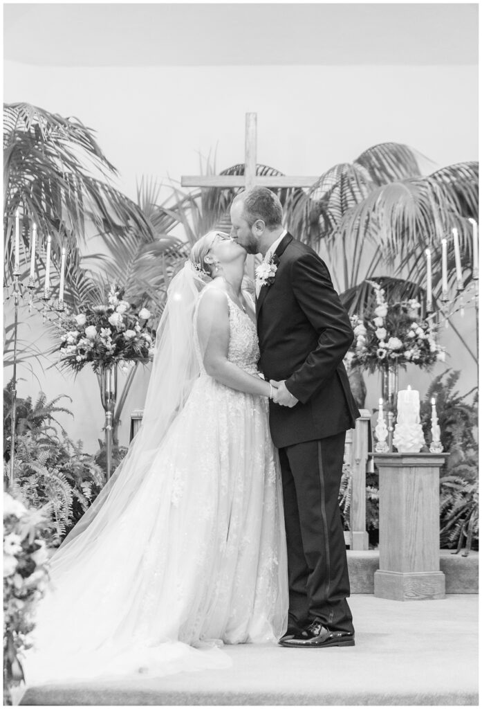 wedding couple share kiss at the end of the church ceremony 