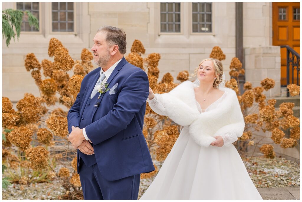 first look with the bride and her dad outside in the courtyard for winter wedding