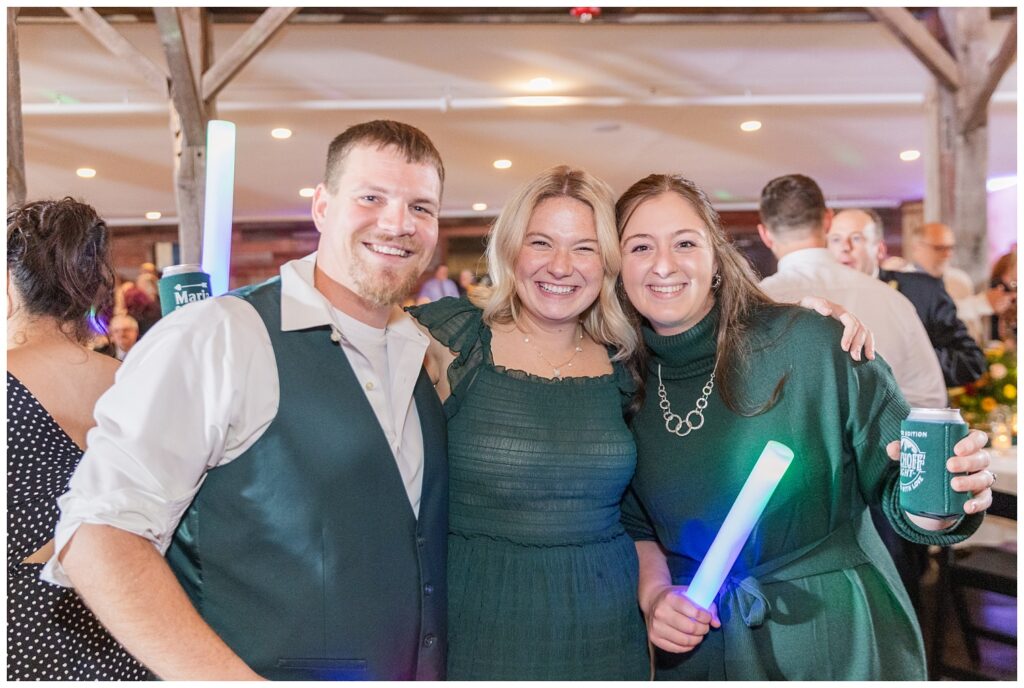 wedding guests posing with light-up foam wands on the dance floor 