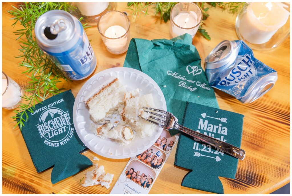 "trash the wedding" portrait that includes beer cans, candles, wedding rings, cake, and koozies