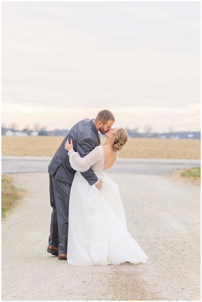 groom dipping back the bride for a kiss on a dirt road in Fremont, Ohio