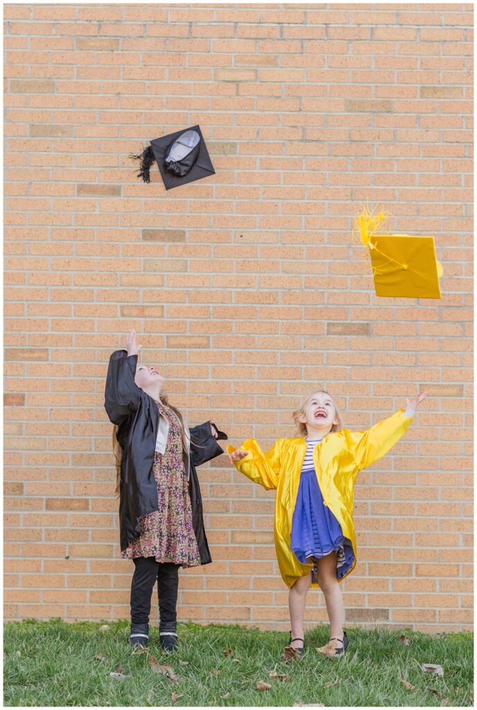 little girls throwing up their caps in the air at Fremont, Ohio graduation mini session