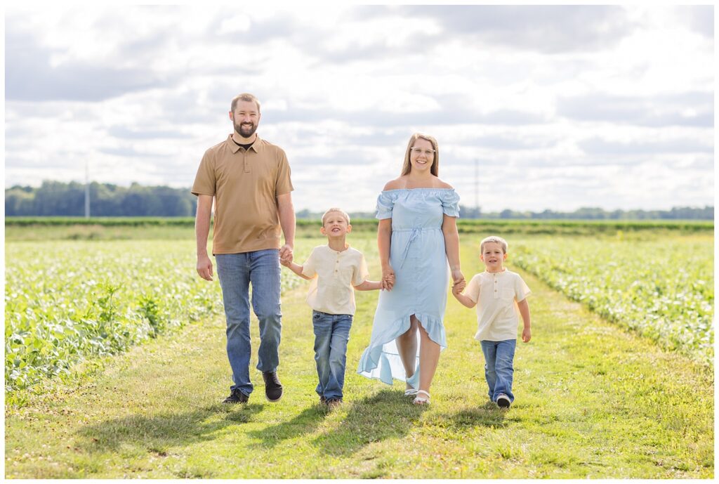 family holding hands and walking along a short field together in Ohio
