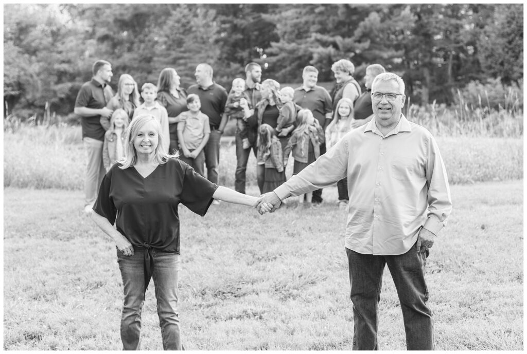 extended family session posing next to a field with Tiffin, Ohio wedding photographer