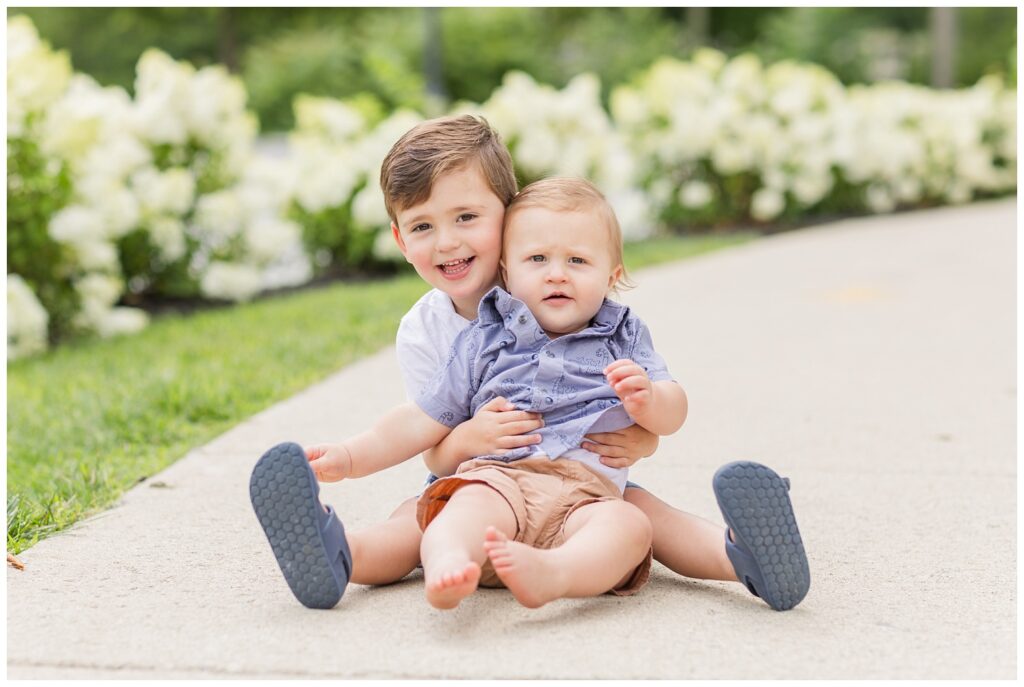 two brothers posing on a sidewalk for a family session in Fremont, Ohio 