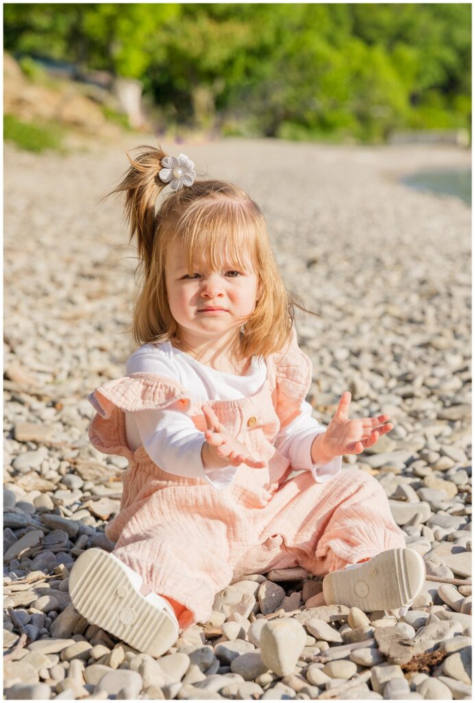 little girl sitting on the stone beach at Lake Erie with Put in Bay photographer