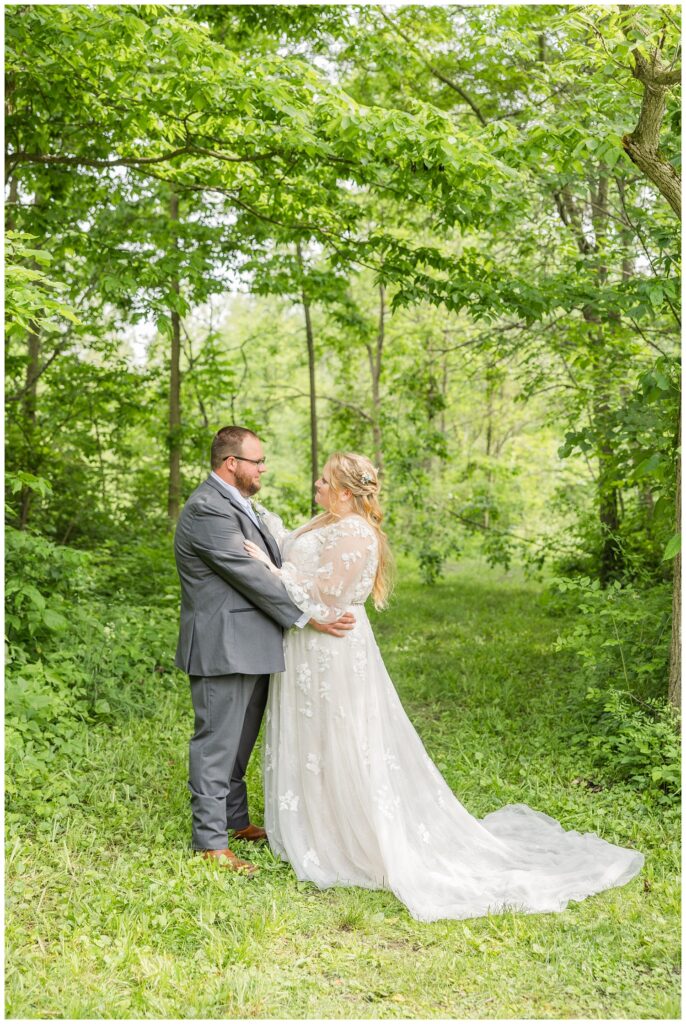 wedding couple holding each other and posing amongst the trees at Bradner Preserve