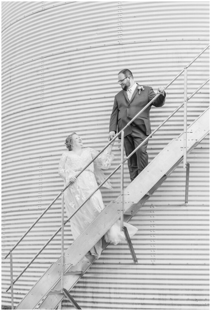 bride and groom posing on the stairs of a grain bin at family farm in Fostoria, Ohio