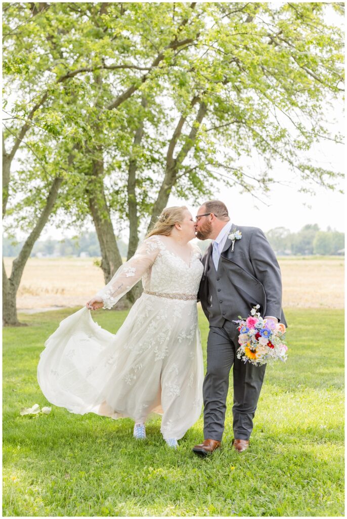 wedding couple walking together and kissing in their backyard in Risingsun, Ohio