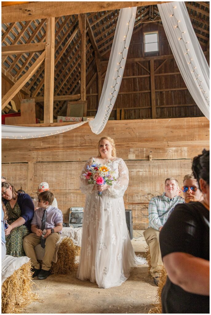 bride walking down the aisle in family barn for Risingsun, Ohio summer wedding