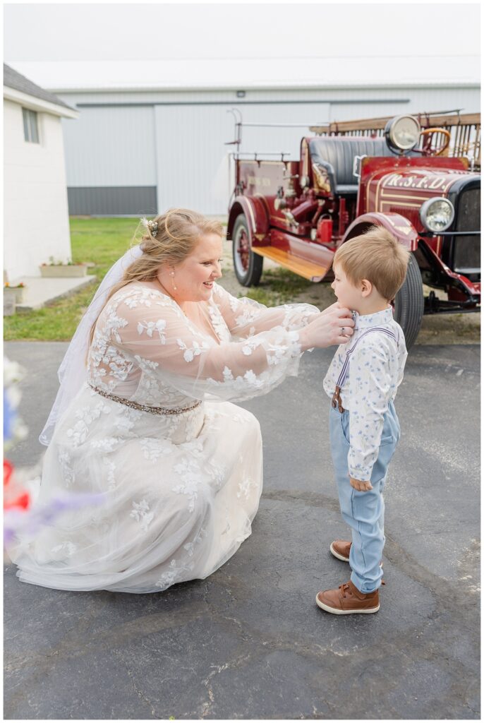 bride adjusting the ring bearer's tie at Risingsun, Ohio family farm