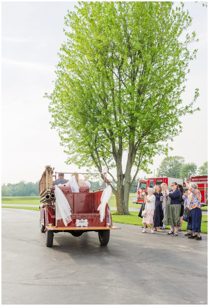 wedding couple taking a ride in a vintage red fire truck from Risingsun, Ohio