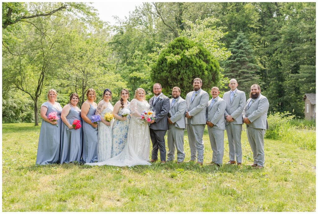 full wedding party posing together at the pond at Bradner Preserve in Ohio