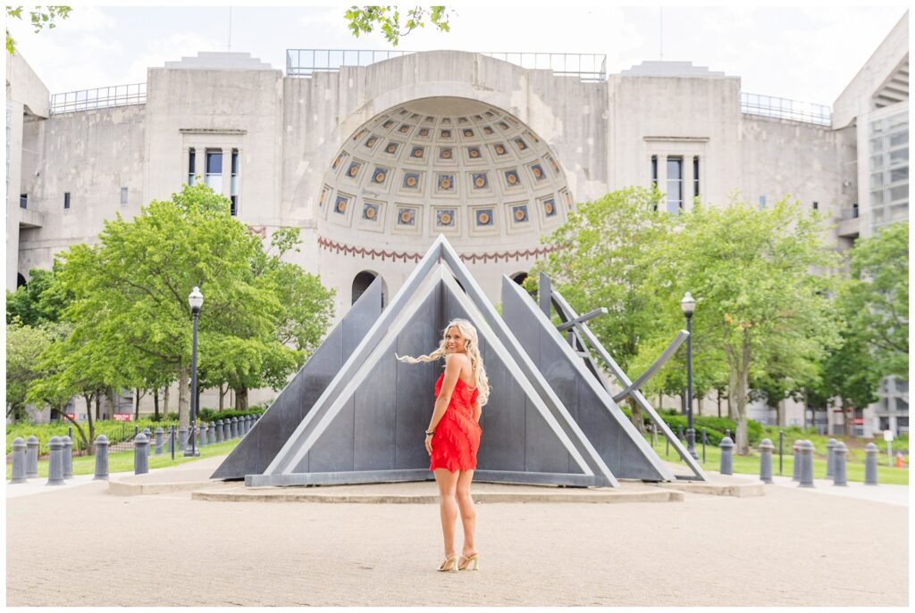 senior girl posing with her back to the camera at Ohio State campus