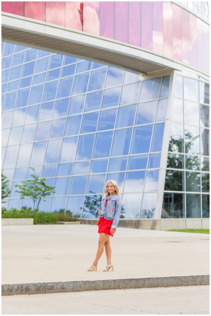 girl posing in front of a large glass building at Ohio State campus in Columbus