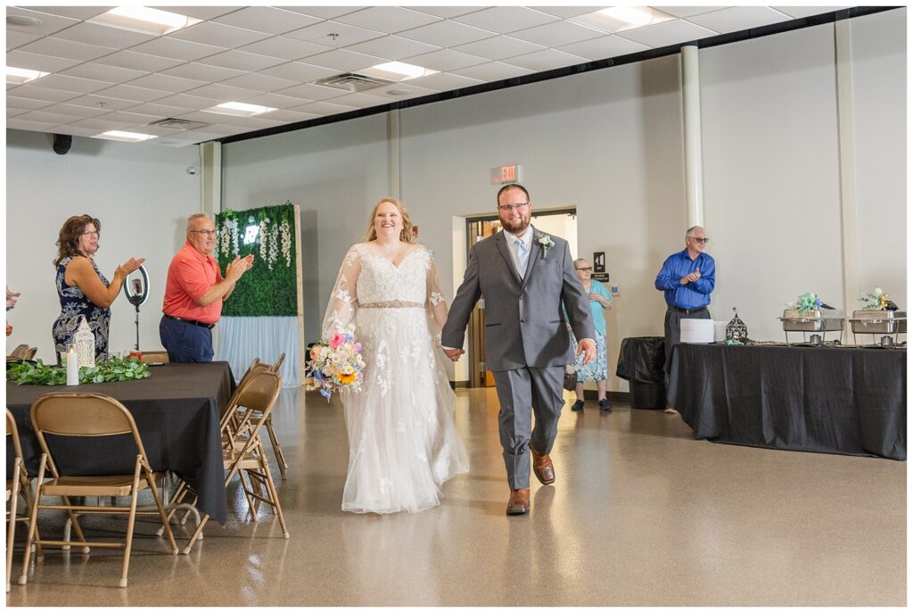 bride and groom walking into their wedding reception at Stacy's Place venue