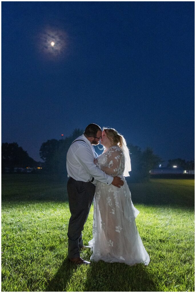 wedding couple share a kiss under the moon at Stacy's Place in Fostoria, Ohio