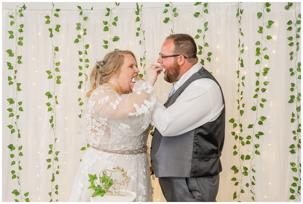 bride and groom feeding each other cake at Fostoria, Ohio wedding reception
