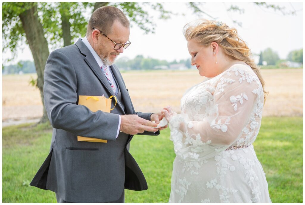 bride giving her dad a gift during their first look outdoors