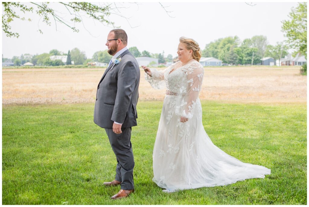 bride touching the back of the groom's shoulder during outdoors first look in Ohio