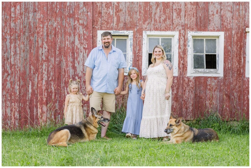 family posing together with their dogs at red barn session in Sandusky, Ohio