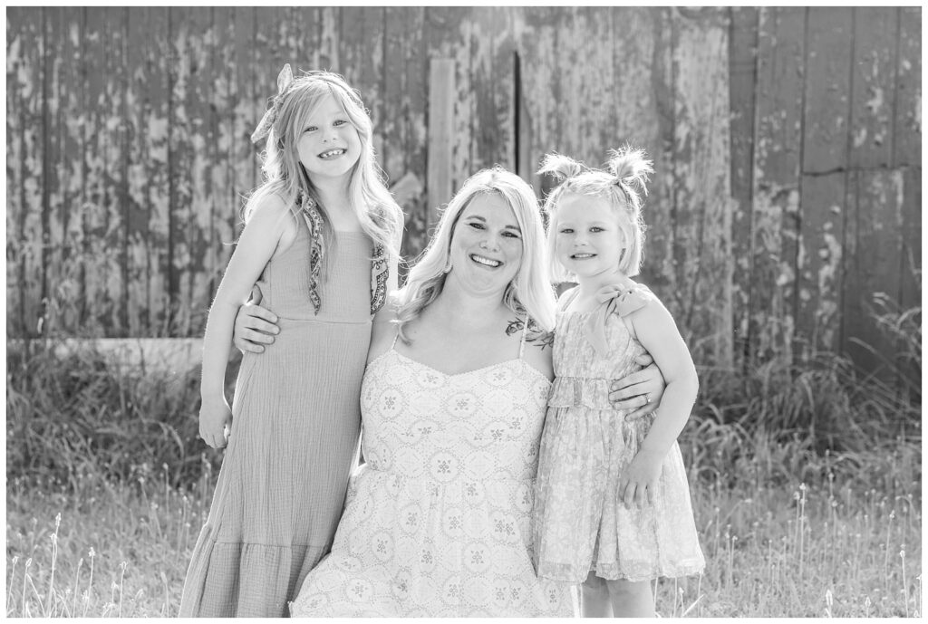 mom kneeling down while hugging her two daughters at Fremont, Ohio family session
