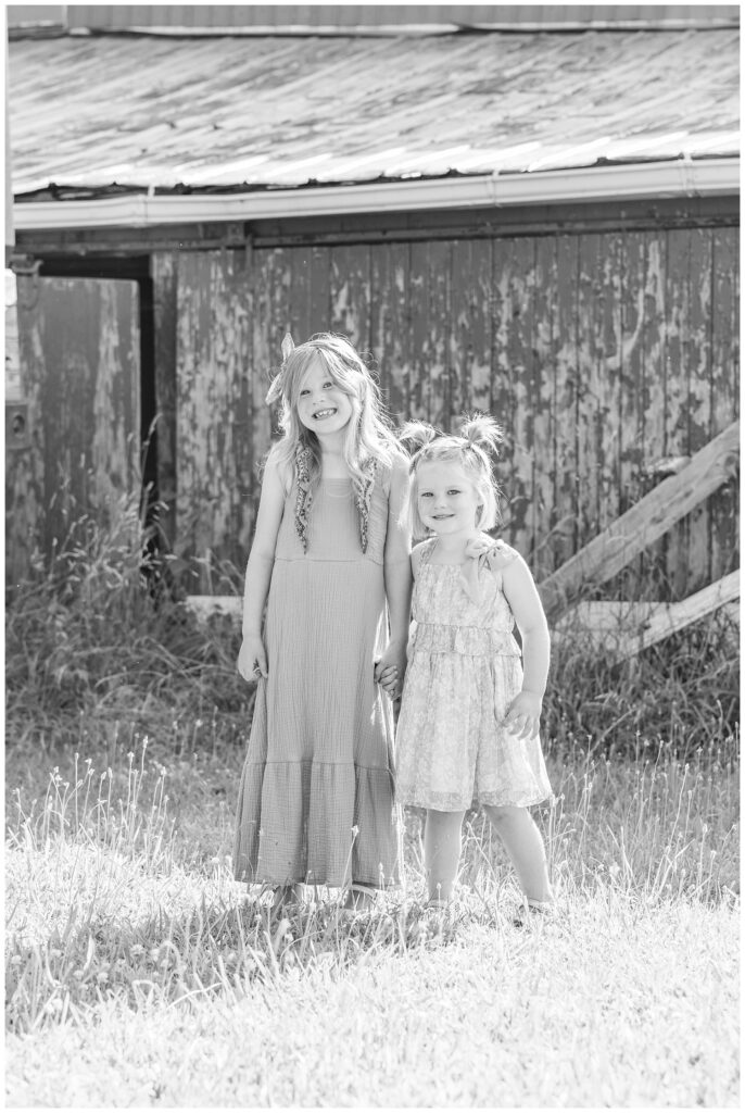 two girls standing and holding hands on a farm for Fremont, Ohio family session