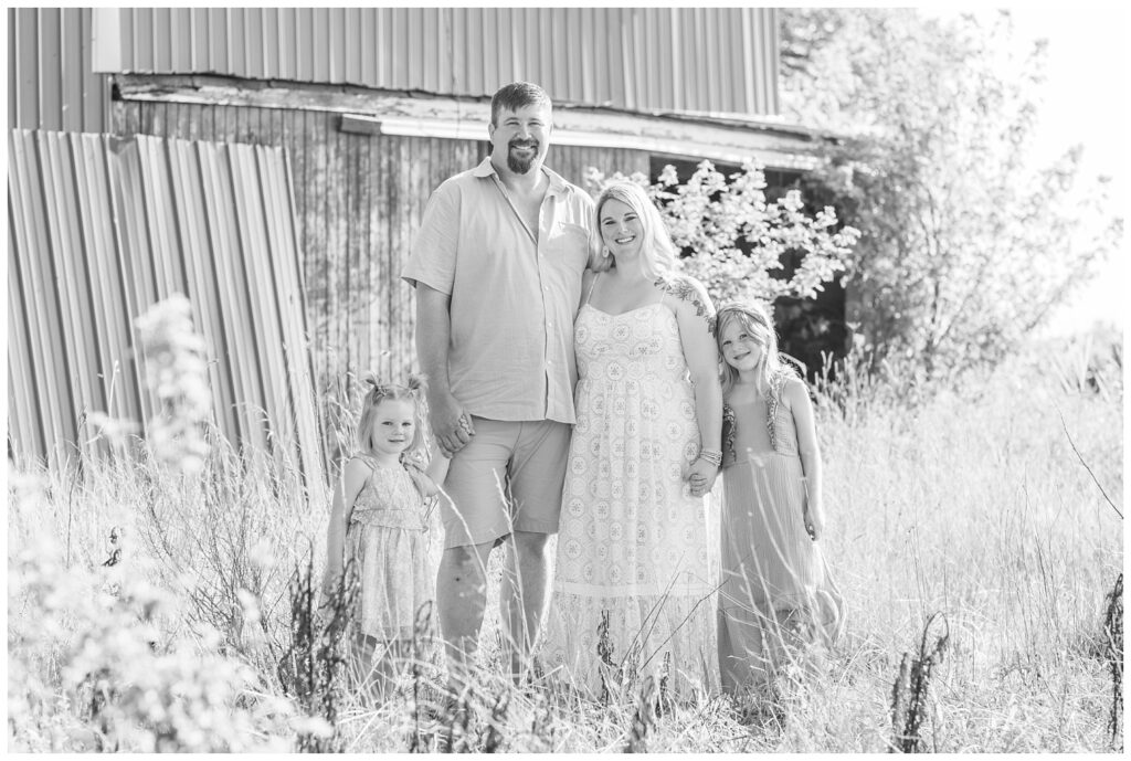 family holding hands and posing together for summer session at Fremont, Ohio red barn