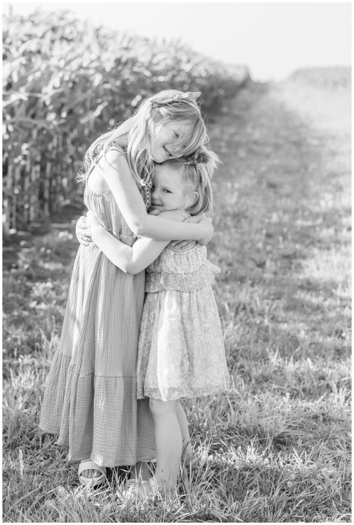 daughters hugging each other while posing next to a corn field in Fremont, Ohio