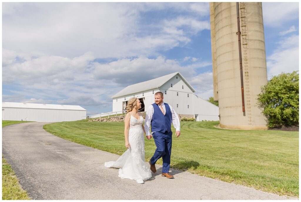 wedding couple holding hands and walking together at Arlington Acres