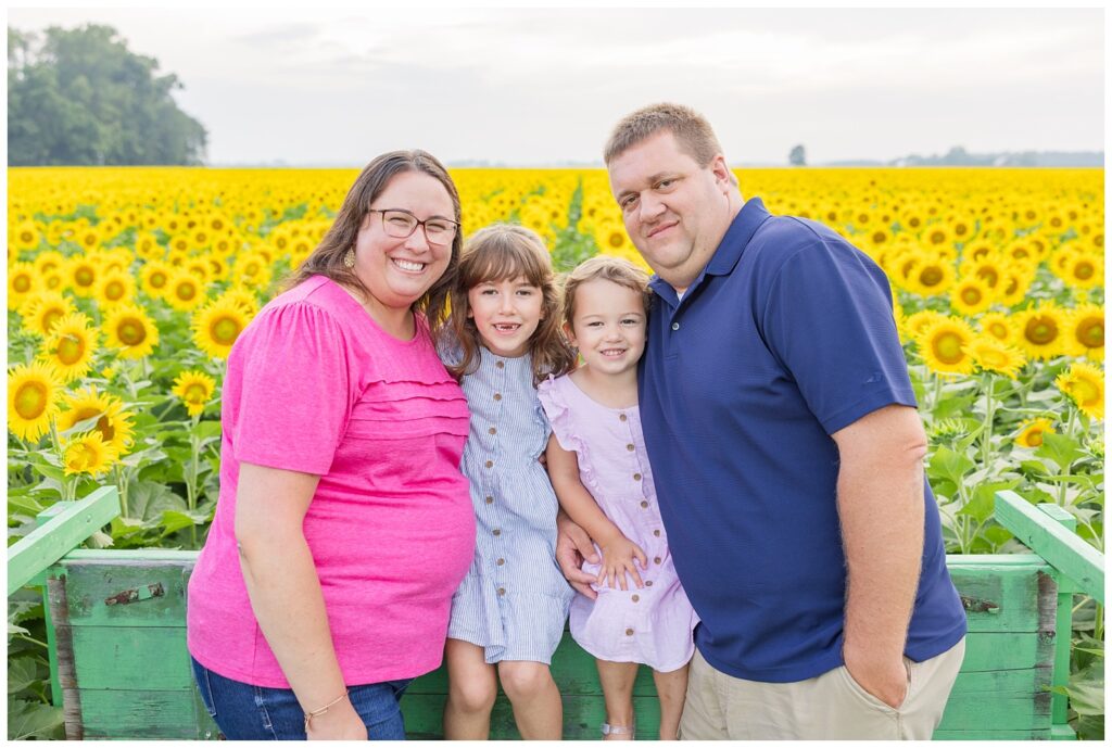 family posing in the back of a green truck at The Suns Flower Farm in Lindsey, Ohio