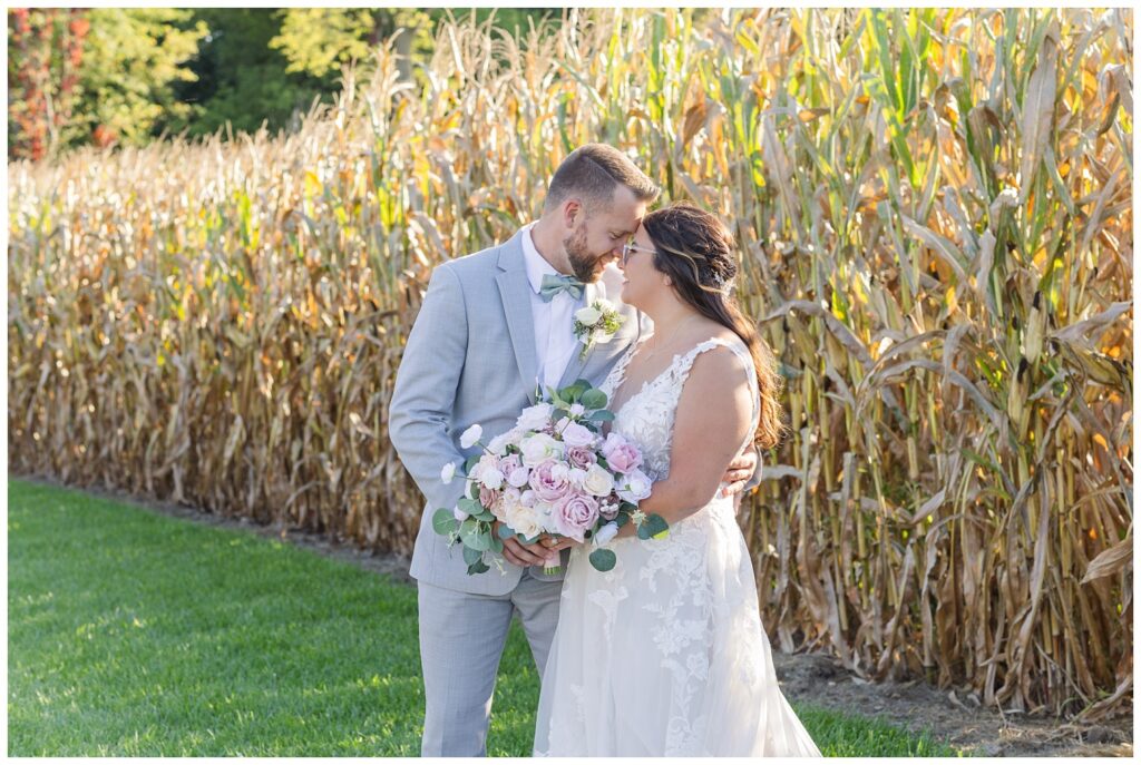 bride and groom standing in front of a corn field at Arlington Acres venue