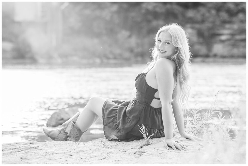 girl sitting on the bank of the river at Tindall Bridge senior session