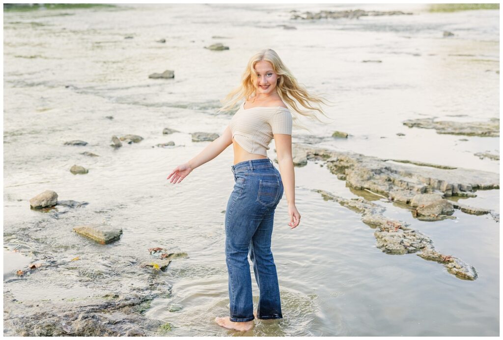 girl twirling in the water at Tindall Bridge senior session in Ohio
