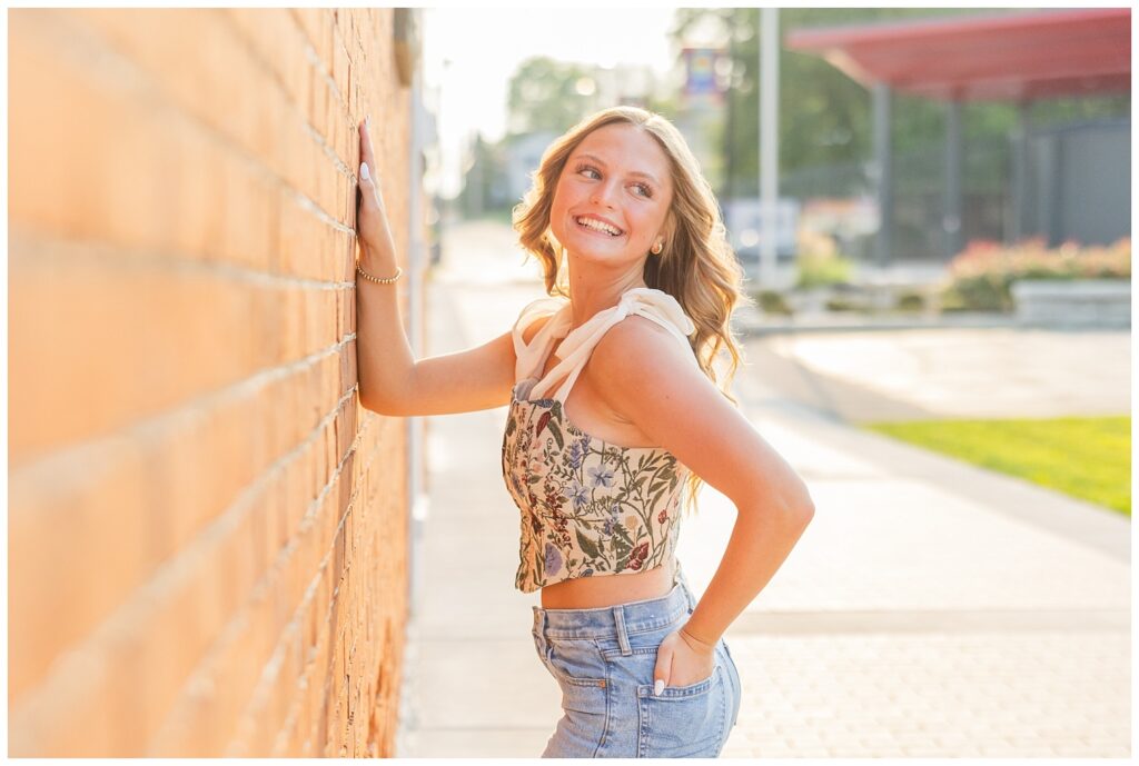 senior girl posing against a brick wall in downtown Fremont, Ohio