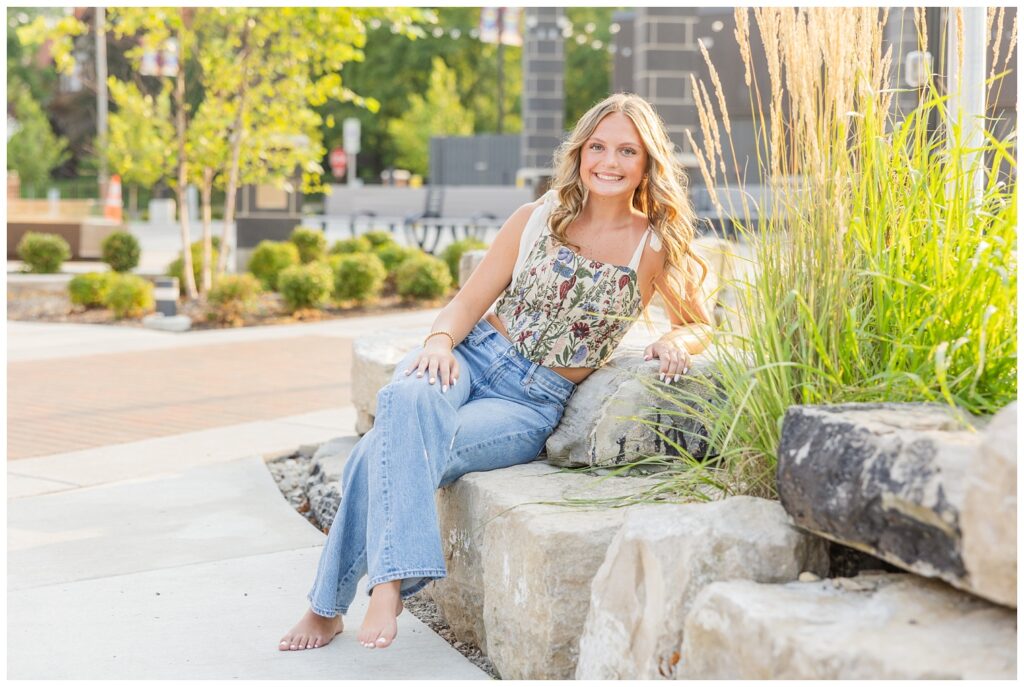 girl sitting on rock sculpture for senior session in Fremont, Ohio