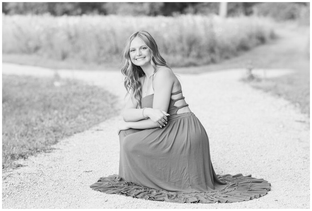 high school senior squatting on a pathway in Don Miller Park in Ohio