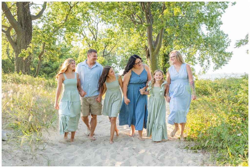family all holding hands and walking on a sand path at East Harbor State Park in Sandusky