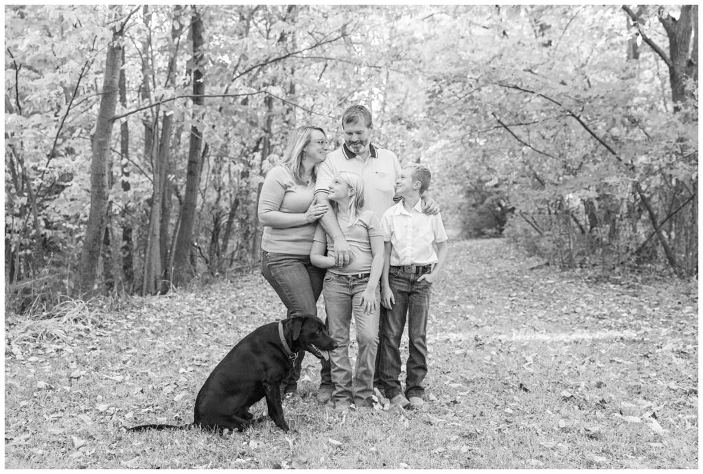 family posing on a wooden trail for portrait session on their property in Tiffin, Ohio