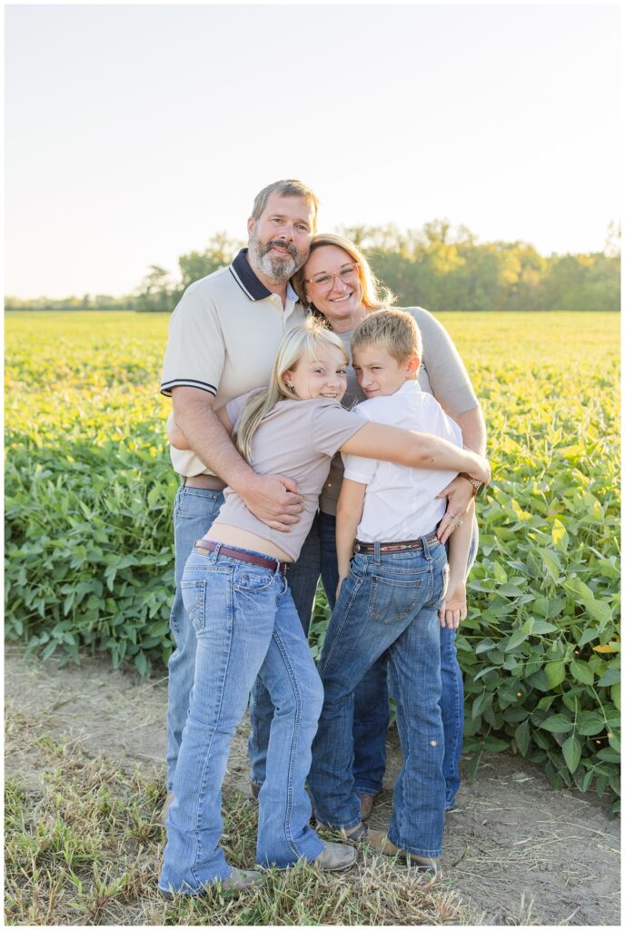 family hugging together in front of their soybean field in Tiffin, Ohio