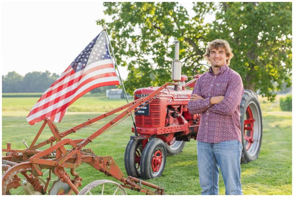 high school senior posing in front of his red tractor in Fremont, Ohio
