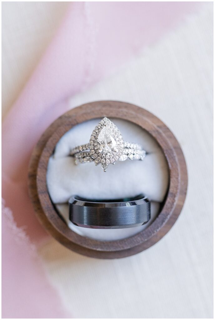 bride and groom's wedding rings sitting in a circle wooden box